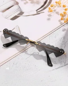 Détail de lunettes de soleil sans monture en forme de nuage avec branches en métal doré