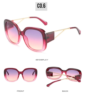 Macro detail of oversized square sunglasses with burgundy frame and gold metal temples