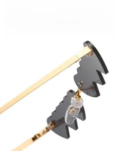 Détail de lunettes de soleil cœur en métal doré avec verres gris dentelés