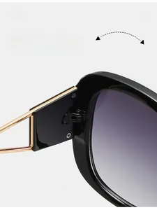 Close-up of durable metal hinges and gold temples on black oversized sunglasses