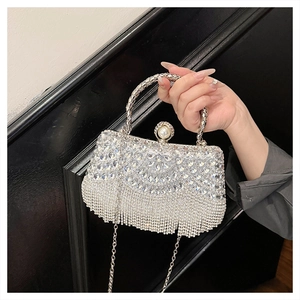 Detail of silver evening bag featuring rhinestone tassels and a large pearl clasp