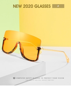 Detail of oversized shield sunglasses with orange gradient lenses and gold metal temples