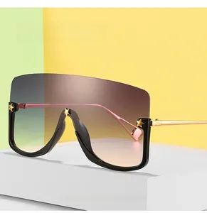 Macro detail of oversized gradient lens sunglasses featuring gold star rivets and metal arms