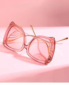 Détail des verres roses en forme d'ailes de papillon avec monture élégante en métal doré