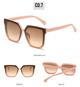Detail view of pink and brown oversized sunglasses with textured diamond pattern arms