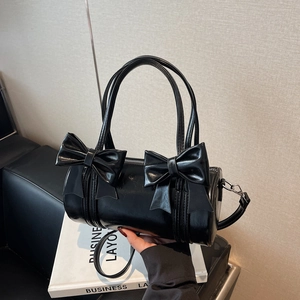 Glossy black barrel handbag with bow details and adjustable strap for women