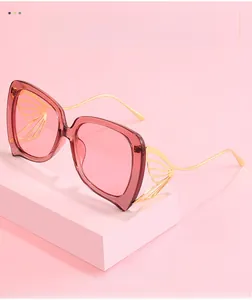 Détail de lunettes de soleil papillon avec branches dorées en forme d'ailes