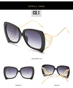 Détails des charnières papillon dorées sur lunettes de soleil noires dégradées