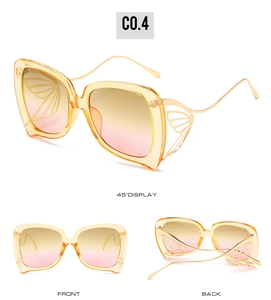 Détails de lunettes papillon avec ailes dorées ajourées et verres jaunes à dégradé doux