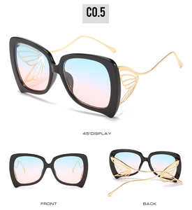Détail de lunettes de soleil papillon avec ailes évidées et verres dégradés bleu rose