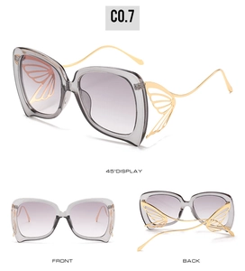 Vues détaillées de lunettes papillon avec ailes en métal doré et verres dégradés gris
