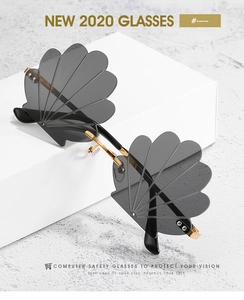 Macro detail of rimless shell shaped sunglasses with gold metal bridge and wavy edges