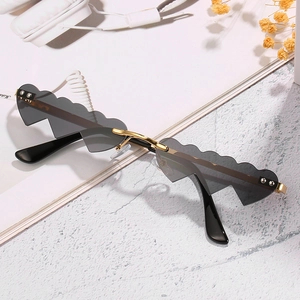 Lunettes de soleil cœur ondulées originales avec monture dorée et verres gris foncé