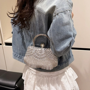 Silver rhinestone tassel handbag with pearl clasp shown on a crossbody shoulder strap