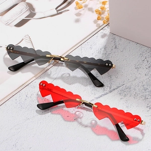 Lunettes de soleil sans monture en forme de cœur ondulé noir et rouge sur marbre