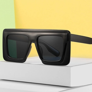 Modern flat top oversized square sunglasses with matte black frames on geometric props