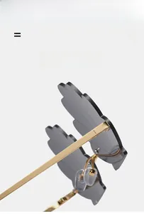 Detail of cloud-shaped sunglasses with translucent grey lenses and golden metal frame