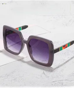 Détail de lunettes de soleil carrées avec verres dégradés violets et branches rayées