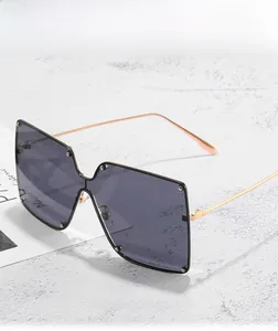 Detail of oversized square rimless sunglasses with silver studs and rose gold metal temples