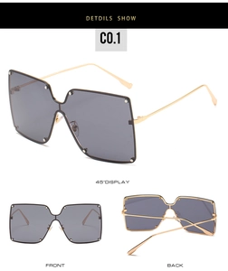 Detail view of oversized square shield sunglasses with gold metal temples and rivets