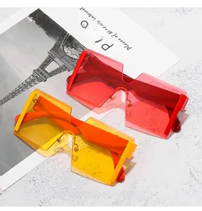 Detail of red and yellow rimless oversized square sunglasses on vintage postcards
