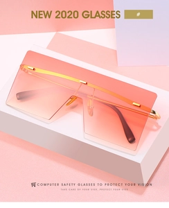 Detail of square oversized sunglasses with orange gradient lenses and gold metal frame