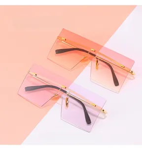 Detail of oversized rimless square sunglasses with gradient orange and pink lenses
