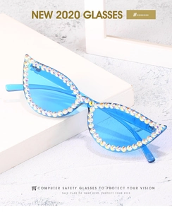 Close-up of cat-eye sunglasses with blue lenses and hand-set iridescent rhinestones
