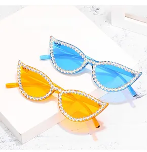 Detail of cat-eye sunglasses featuring hand-set rhinestones in blue and orange frames