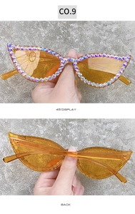 Detail view of orange cat eye sunglasses with hand-set rhinestones and amber lenses