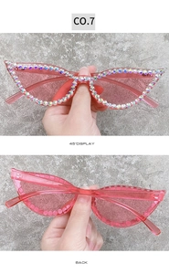 Detailed close-up of pink cat-eye sunglasses featuring hand-set colorful rhinestones