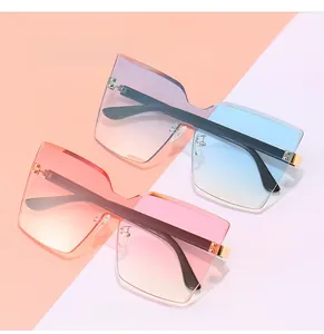 Détail de lunettes de soleil carrées sans monture avec pont métallique doré élégant