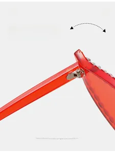 Detail of durable metal hinges and colorful rhinestones on red cat eye sunglasses