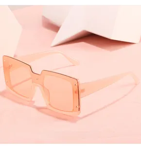 Détail de lunettes de soleil carrées roses transparentes avec rivets sur un fond
