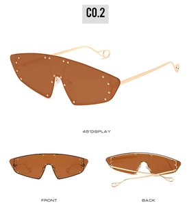 Detail view of cat eye sunglasses with gradient lenses, gold rivets, and metallic hollow tips