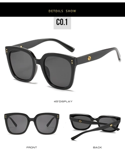 Detail view of black oversized sunglasses with golden rivets and hollowed temple logo