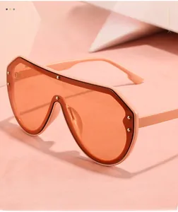 Makro-Detail der pfirsichrosa Oversized-Sonnenbrille mit Nieten auf dem Gestell