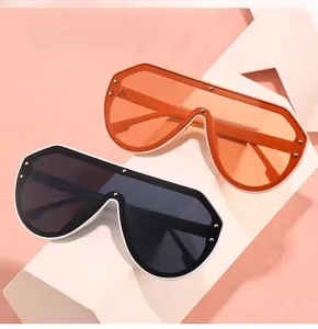 Detailansicht der Oversize-Schild-Sonnenbrille mit Metallnieten in Schwarz und Orange