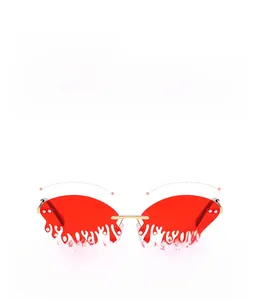 Macro detail of red teardrop-shaped rimless sunglasses with rhinestone-encrusted edges