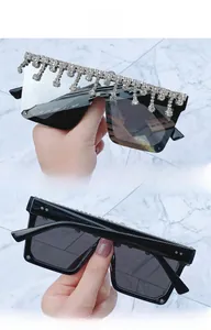 Close-up of oversized square sunglasses with sparkling silver rhinestone trim on black frames