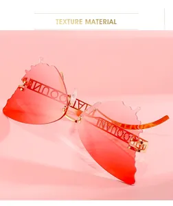 Detail of butterfly-shaped rimless sunglasses with pink gradient lenses and gold metal arms