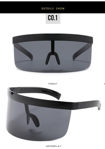 Dettaglio degli occhiali da sole a maschera neri oversize con design della montatura avvolgente