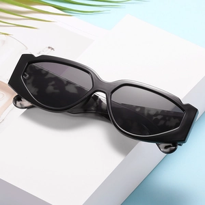Occhiali da sole esagonali cat eye con stanghette marmorizzate su supporto bianco