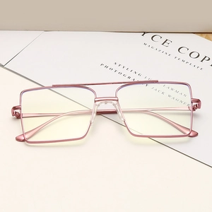 Monture de lunettes carrée en métal or rose à double pont sur un magazine