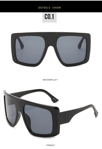 Macro view of oversized square sunglasses with dark grey lenses and black frames