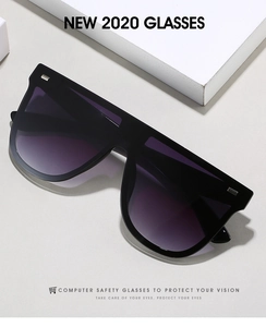 Detail der übergroßen schwarzen Sonnenbrille mit lila Verlaufsgläsern und Metallnieten