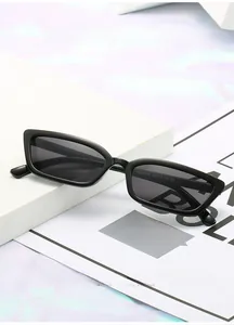 Détail de lunettes de soleil rétro rectangulaires noires sur des marches blanches