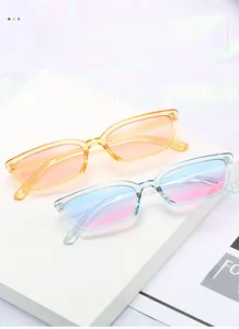 Gros plan sur des lunettes de soleil rétro rectangulaires aux montures orange et bleu