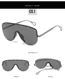 Vue détaillée de lunettes de soleil grand format avec verres gris et rivets en métal