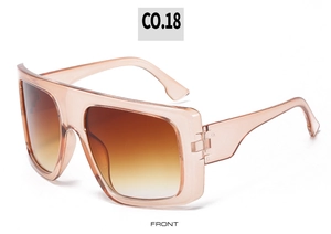 Close-up of pink translucent oversized sunglasses with gradient brown lenses